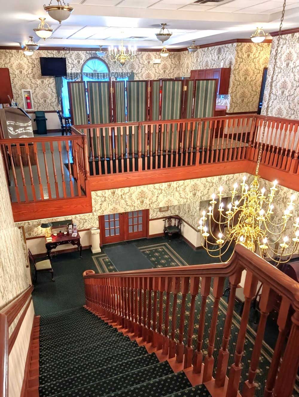 A view of the foyer front the top of the stairs, also in view is the lounge area.